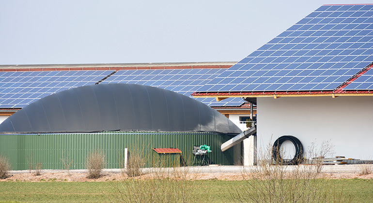 Lada med solceller på taket och en biogasanläggning intill.