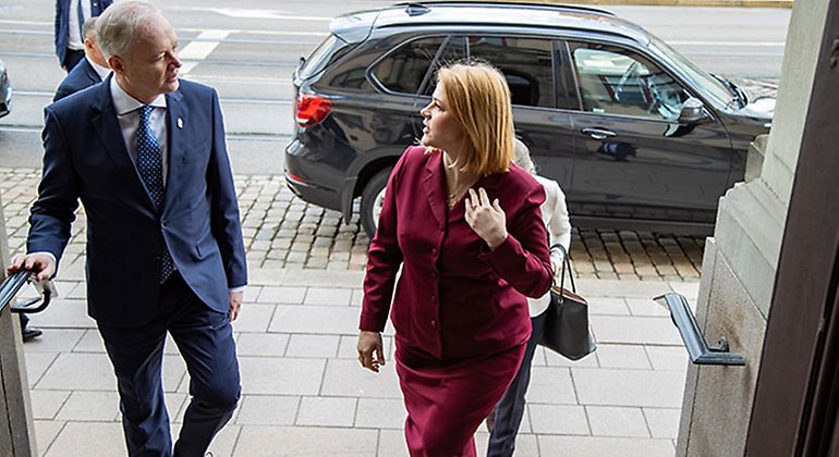 Landshövding Sten Tolgfors och Lettlands premiärminister Evika Silina ser mot varandra när de går in genom porten till residenset. 