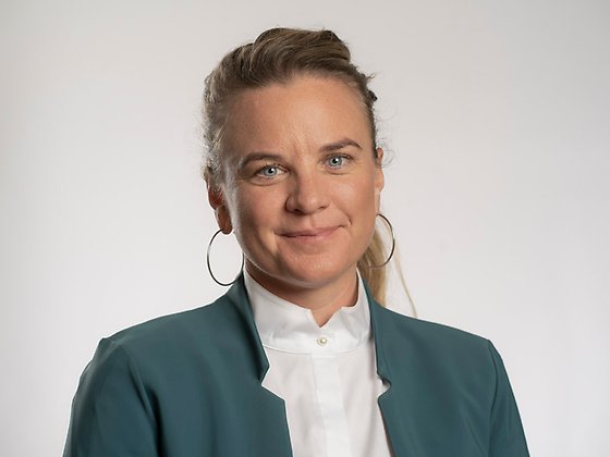 Länsråd Johanna Sandwall står framför en ljusgrå bakgrund