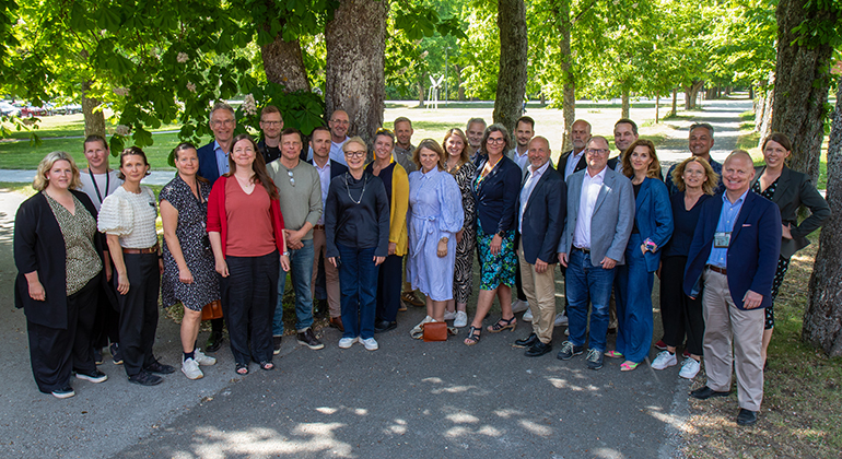 En större grupp människor uppstälda för fotografering.
