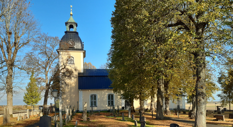 Ekeby kyrka med kyrkogården i förgrunden