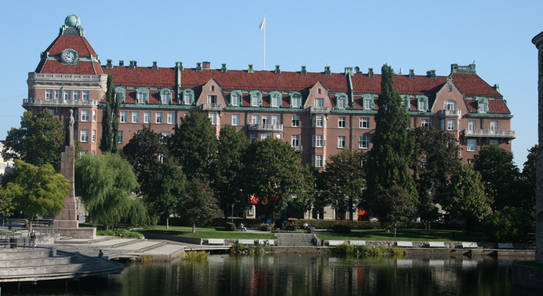 Centralpalatsen med parken och Svartån i förgrunden, sommar med gröna träd