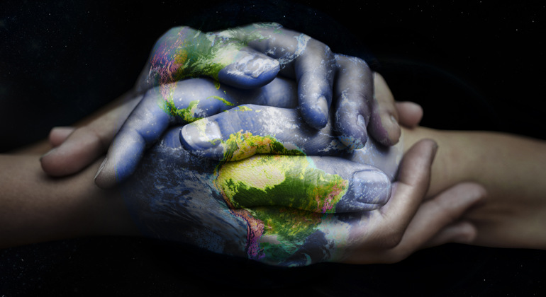 Två händer som kramar om varandra och är målade som något som symboliserar världen