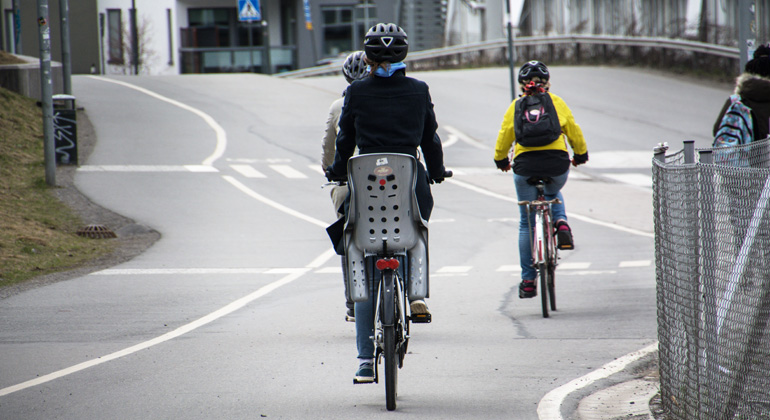 Cyklister färdas på en cykelbana i urban miljö.