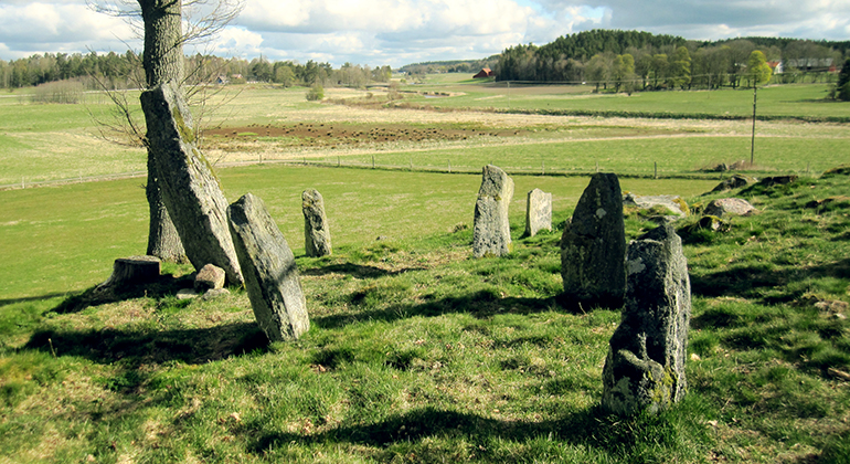 Ett antal gamla gravstenar står på en gräsbeklädd kulle.