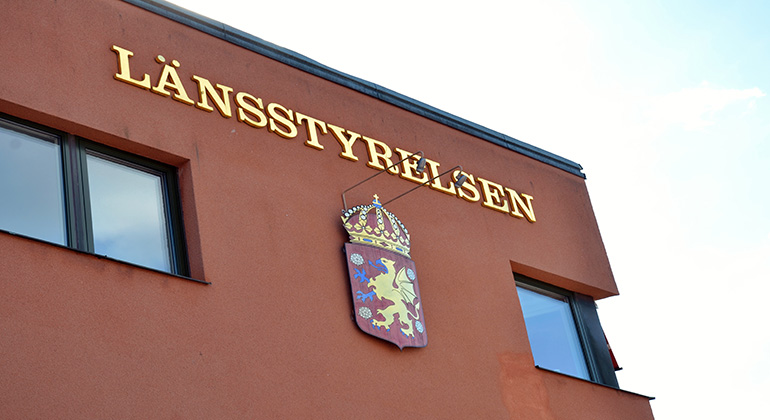 Genrebild på Länsstyrelsens kontorsbyggnad. Länsstyrelsens logotyp syns mot en orangefärgad fasad.