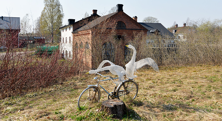 I parken finns ett konstverk med två svanar på en cykel