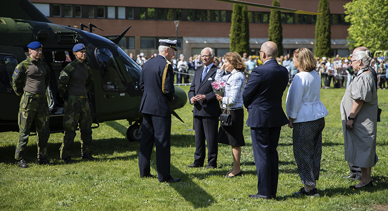 Kungaparet och landshövdingeparet med flera pratar med flottiljchef överste Mats Antonson intill Helikopter 15
