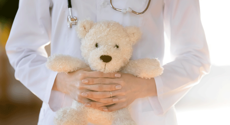 Sjukvårdspersonal som kramar en nallebjörn. 