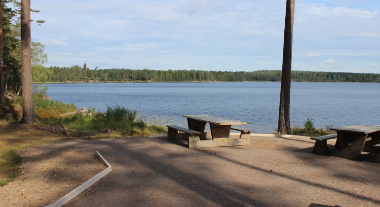 Bilden visar en picknick-plats vid en insjö.