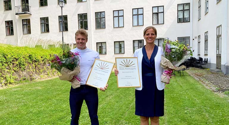 Kalle Gustafsson och Lotta Carlsson står med varsitt diplom och varsina blombuketter.