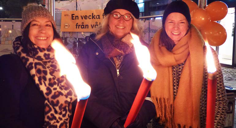 Susanna Karlsson-Arnberg, Susanne Jansson och Mariah Andersson håller varsin fackla.