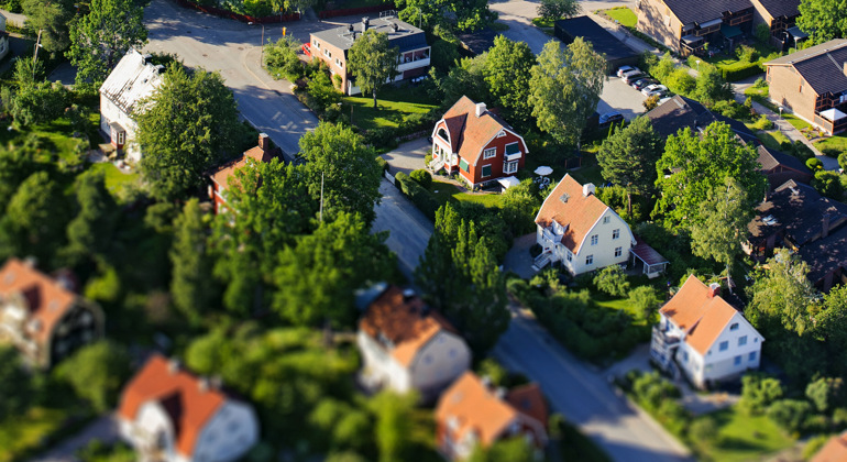 Ett bostadsområde med småhus och trädgårdar sett från ovan.