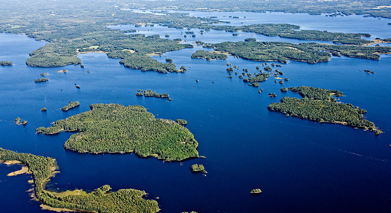 Flygbild på Åsnen uppifrån med gröna öar och blå sjö