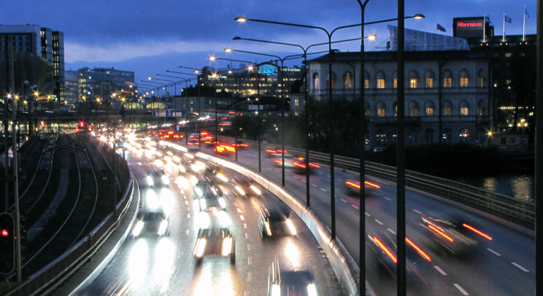 Nattvy över centralbron i Stockholm med passerande bilar.