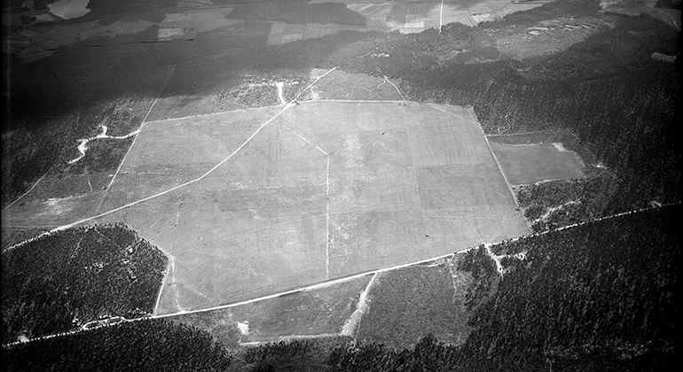 Svartvit flygbild från 1943 över Brattforshedens krigsflygfält. Efter varsam restaurering ser flygfältet idag ut till stora delar så som det gjorde på 40-talet.