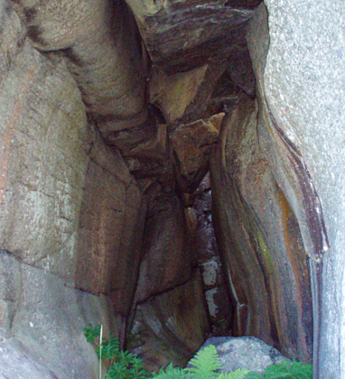 Foto av en rund grotta in i berget.