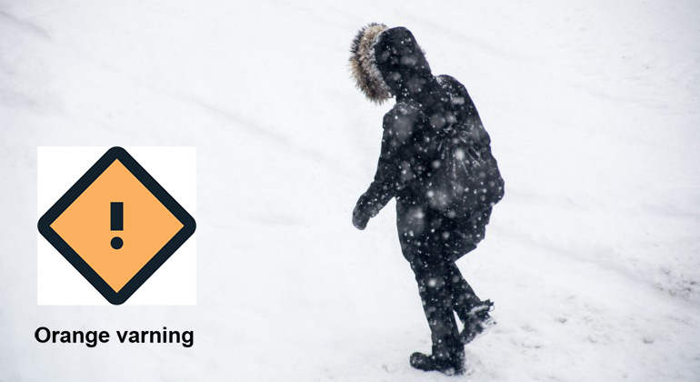 En person promenerar i kraftigt snöoväder. En orange varningstriangel och texten Orange varning.