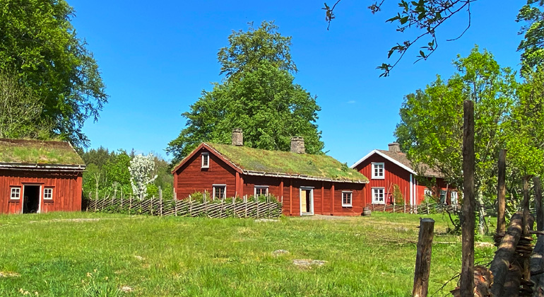 Gamla röda hus i lantlig miljö.