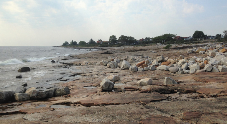 Stenhällar med stenblock längs strandlinjen. Foto: Ann-Sofie Pellas