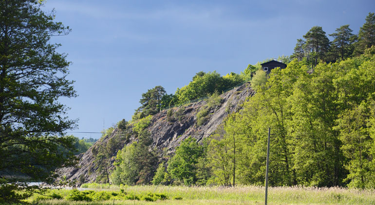 Stuga på en bergknalle i Hammarbergets naturreservat, högt över sjö och grönska. Foto: Länsstyrelsen