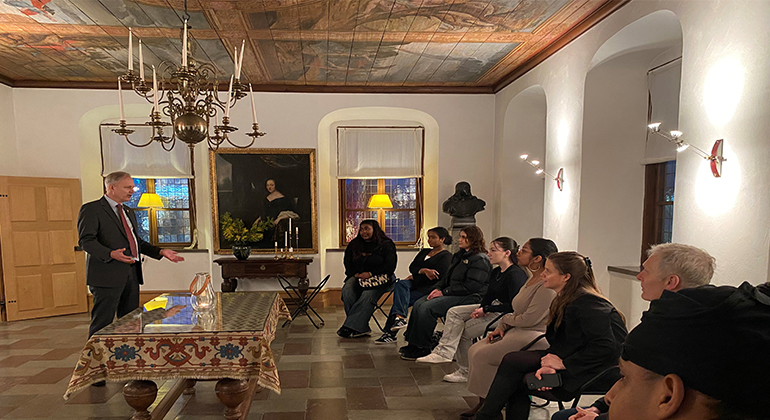 Ungdomar sitter och lyssnar på landshövding Sten Tolgfors som pratar i en gammal sal i residenset i Göteborg. 
