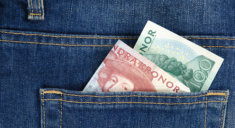 Närbild av en bakficka på ett par jeans med sedlar som sticker upp.