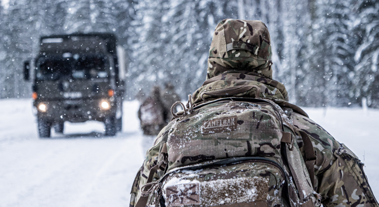 Brittisk soldat och fordon övar på en vintrig väg i Estland.