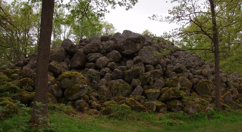 Ett stort stenröse med stora mossbeklädda stenar.