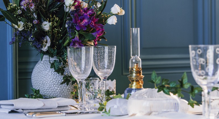 Ett vacker dukat bord med blommor och vinglas