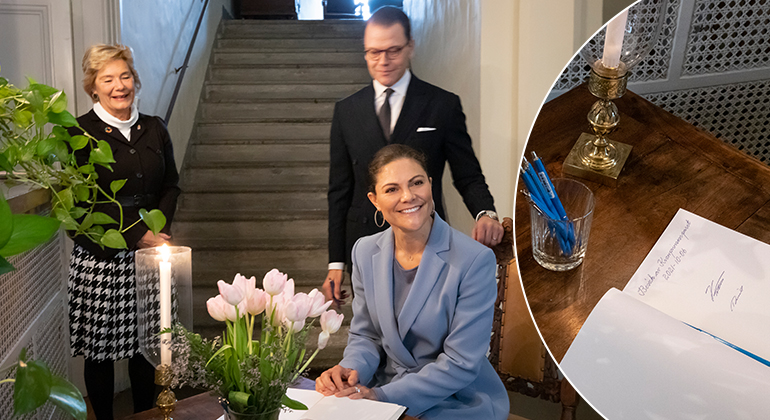 Kronprinsessan skriver i gästboken. Prins Daniel och Landshövding Maria Larsson står bakom.