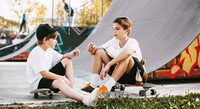 Två barn vid skatepark.