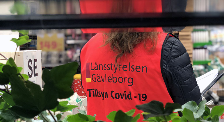 Tillsynsperson i varselväst med Länsstyrelsen Gävleborgs logotyp på.