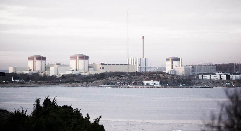 Bild visar Ringhals kärnkraftverk från lite avstånd med vatten i förgrunden. 