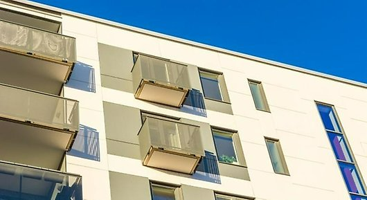 Fasad av lägenhetshus med balkonger nerifrån