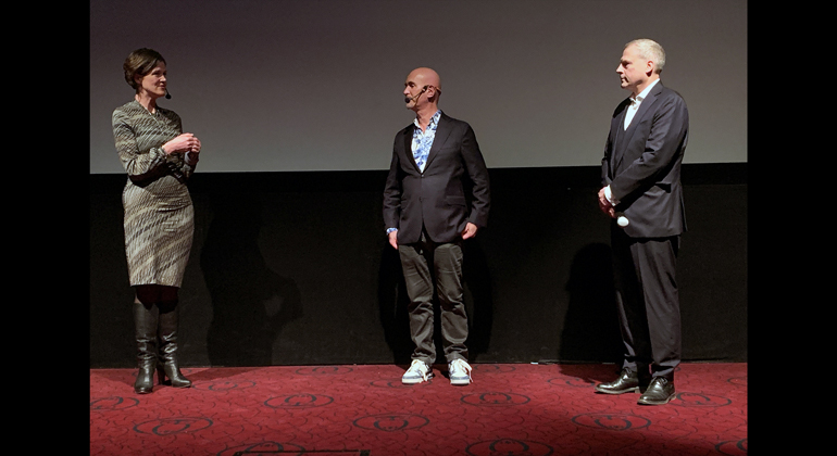 Landshövding Anna Kinberg Batra, Micael Bindefeldt filmskaparen Johan Palmgren i samtal på en scen. 