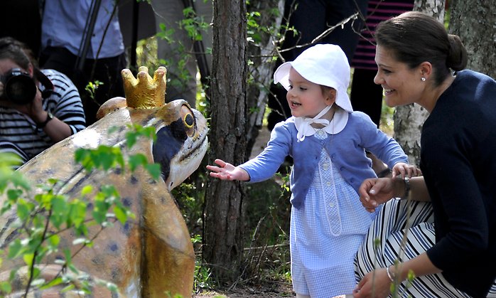 Prinsessan Estelle, två år, klappar en groda uthuggen ur trä. 