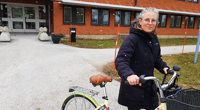 Agneta Green är energi- och klimatsamordnare vid Länsstyrelsen i Gotlands län. På bilden leder hon en cykel, i bakgrunden skymtar länsstyrelsens byggnad på Visborgsområdet i södra Visby.