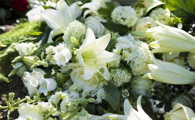 Närbild på en bukett vita begravningsblommor, bland annat lilja