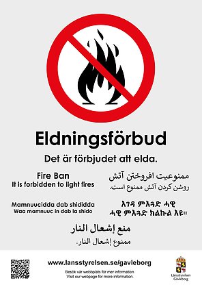 Affischen har ett förbudsmärke över en eld och text på flera språk. 