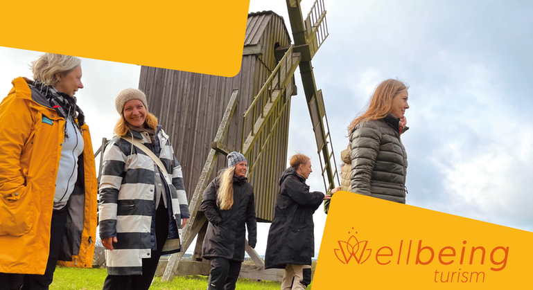 Fem kvinnor utomhus framför en vindsnurra på Öland