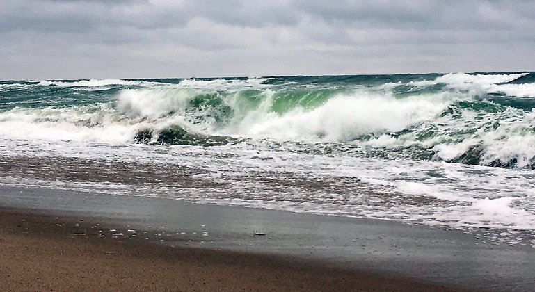 Höga vågor som slår mot stranden.