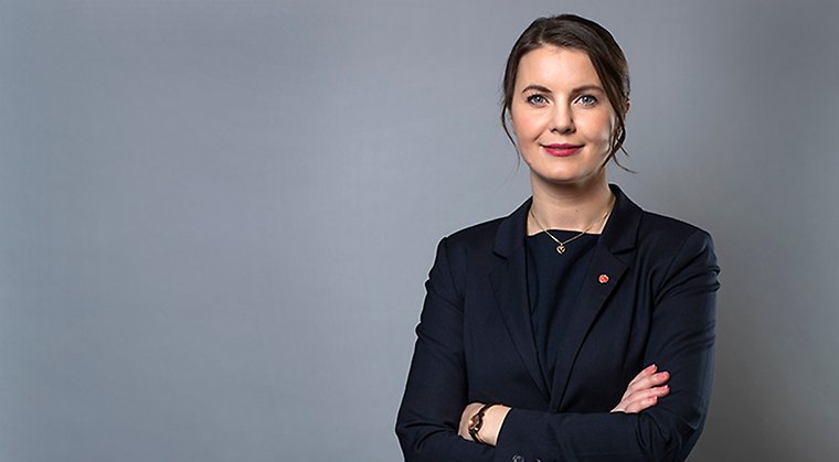 Civilminister Ida Karkiainen i mörk kavaj mot en grå bakgrund.