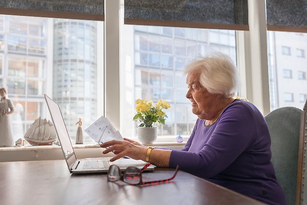 Äldre kvinna framför dator