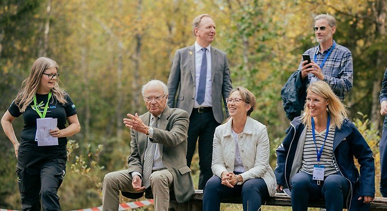 En grupp människor sitter på en bänk.