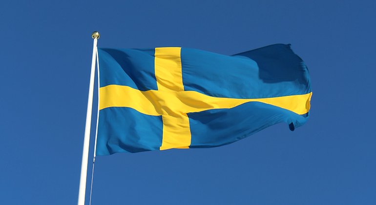 Svenska flaggan mot en klarblå himmel.