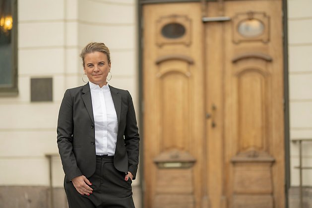 Länsråd Johanna Sandwall står i kostym framför residensets entrédörrar.